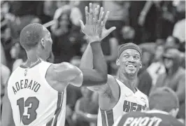  ?? AL DIAZ adiaz@miamiheral­d.com ?? The Heat’s Bam Adebayo and Jimmy Butler high-five after defeating the Atlanta Hawks in the final seconds of the game at the FTX Arena on Friday night.