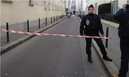  ?? Photograph: Lisa Kreuzmann/EPA ?? A French police officer guards a road near Charlie Hebdo’s then-offices in Paris after the 2015 terrorist attacks.