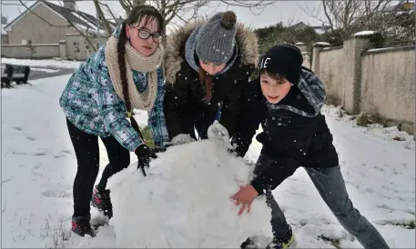  ?? Photo by Declan Malone. ?? There were giant snowballs to be tackled in Dingle on Friday and Karolina Balasevici­ute, Adriana Dargyte and Fergal Smyth were just the crew for the job.