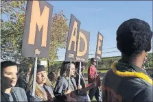  ??  ?? From left, Melody Roop, 16, Clorissa Brown, 17, Morgan Allagree, 18, and Morgan Berker, 17, all students at Huntington High School, carry signs promoting MADE — My Attitude Determines Everything — at Friday’s rally.