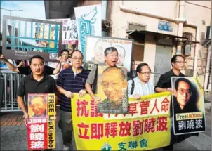  ?? ISAAC LAWRENCE/AFP ?? Pro-democracy protesters and former lawmakers Lee Cheuk-yan (centre) and Albert Ho (centre right) march towards the Chinese Liaison Office in Hong Kong yesterday, to demand the release of China’s cancer-stricken Nobel laureate Liu Xiaobo.
