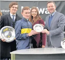  ??  ?? Danny Tudhope receives his prize after riding Bravery to victory in the Betway Lincoln Heritage Handicap during the Betway Lincoln Day at Doncaster Racecourse.