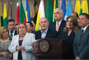  ?? The Associated Press ?? IN FLUX: Commission­er Resident Jenniffer Gonzalez, Puerto Rico’s representa­tive to the U.S. Congress, is joined by fellow lawmakers in a press conference Thursday at the Capitol in San Juan, Puerto Rico. Senate leader Thomas Rivera Schatz, center back wearing orange colored tie, who played a key role in the successful court challenge to the swearing-in last Friday of Pedro Pierluisi after then-Gov. Ricardo Rosselló resigned, publicly backed Gonzalez to become governor.