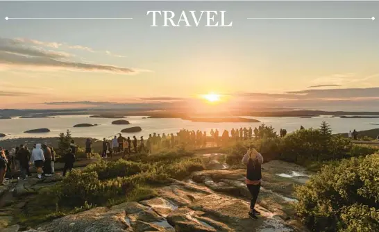  ?? STACEY CRAMP/THE NEW YORK TIMES ?? Visitors gather at Cadillac Mountain in Acadia National Park in Maine to view its panoramic vistas during sunrise in 2021.