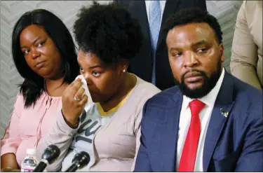  ?? IRWIN THOMPSON/THE DALLAS MORNING NEWS VIA AP ?? Amber Carr, center, wipes a tear as her sister, Ashley Carr, left, and attorney Lee Merritt, right, listen to their brother Adarius Carr talk about their sister, Atatiana Jefferson during a news conference Monday, Oct. 14, 2019 in downtown Dallas. The family of the 28-year-old black woman who was shot and killed by a white police officer in her Fort Worth home as she played video games with her 8-year-old nephew expressed outrage that the officer has not been arrested or fired.
