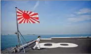  ?? REUTERS ?? Yuma Osaki, a navigator, runs back to her post after a flag raising ceremony on the flight deck of Japanese helicopter carrier Kaga before its departure for naval drills in the Indian Ocean, Indonesia, 22 September.