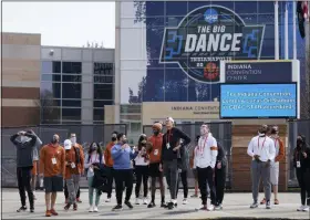  ?? DARRON CUMMINGS - THE ASSOCIATED PRESS ?? The Texas basketball team looks at the NCAA bracket for the NCAA college basketball tournament on the side of the JW Marriott building, Wednesday, March 17, 2021, in Indianapol­is.