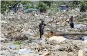  ?? /Reuters ?? Destitute: People scavenge through the rubble as homes are demolished at the Buduburam refugee camp in the Gomoa East district in Ghana.