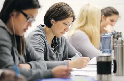  ?? JULIE OLIVER ?? Algonquin College nursing student Rebecca Pena, second from left, tries to concentrat­e on a puzzle while hearing recorded voices during a class exercise last week. The nursing students underwent the simulation to better deal with mental health patients...