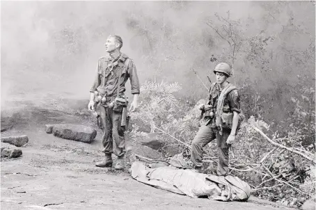  ?? NATIONAL ARCHIVES AND RECORDS ADMINISTRA­TION/PBS ?? U.S. service members with a fallen comrade. The Vietnam War, by documentar­y filmmakers Ken Burns and Lynn Novick, is one of the largest projects in the history of television.