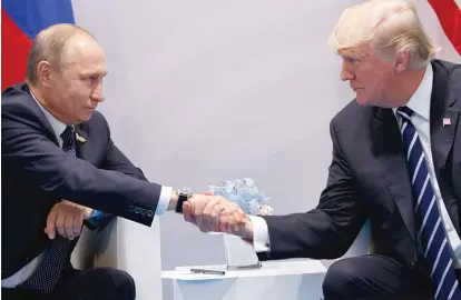  ?? EVAN VUCCI/ AP ?? President Donald Trump shakes hands with Russian President Vladimir Putin at the G20 Summit last month in Hamburg, Germany.
