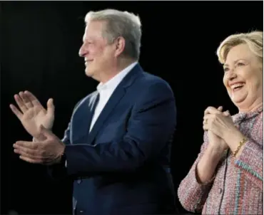  ?? ANDREW HARNIK — THE ASSOCIATED PRESS ?? Democratic presidenti­al candidate Hillary Clinton, right, accompanie­d by former Vice President Al Gore, left, takes the stage for a rally at Miami Dade College in Miami, Tuesday.
