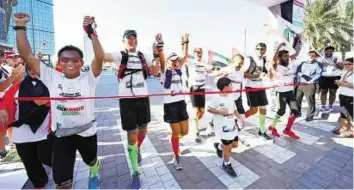  ?? Zarina Fernandes/Gulf News ?? Marlon Elauza, James Constable, Clare Mullenger, Wendelin Lauxen, Luiz Pradines, Scott Williams-Hall and Shaikh Mansour Ali celebrate at the finish line of the 7 Emirates Run at Dubai Festival City yesterday. The event sought to raise Dh777,000 for Al...