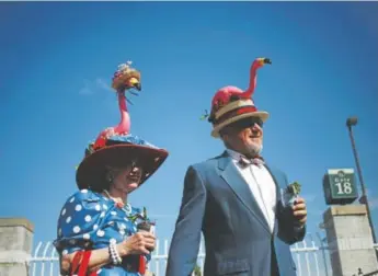  ?? Luke Sharrett, Bloomberg News ?? Jan and Scott Baty wear flamingo-themed Derby hats on the morning of the 140th running of the Kentucky Derby at Churchill Downs in Louisville, Ky. Flamingos are on-trend — for the moment.