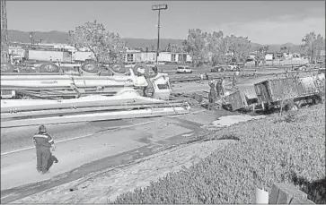  ?? Associated Press ?? A CONCRETE pumping truck lies on its side after crashing through the center divider and into oncoming traffic on the 10 Freeway near Rialto on Friday. The fiery wreck left five people dead, authoritie­s said.