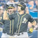  ?? FRED THORNHILL — THE ASSOCIATED PRESS ?? The A’s Chad Pinder, right, celebrates with Matt Joyce after hitting a grand slam against the Blue Jays in the eighth inning.