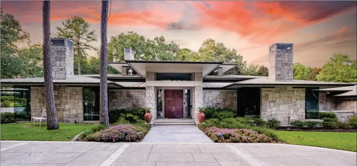  ?? SUBMITTED PHOTOS ?? This two-story stone home provides a metal roof, a stone driveway and beautiful landscapin­g.