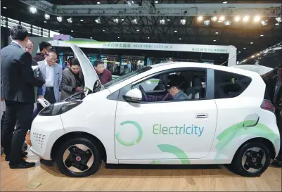  ?? LAI XINLIN / FOR CHINA DAILY ?? Visitors inspect a Roewe e50 electric car at an auto fair in Shanghai.