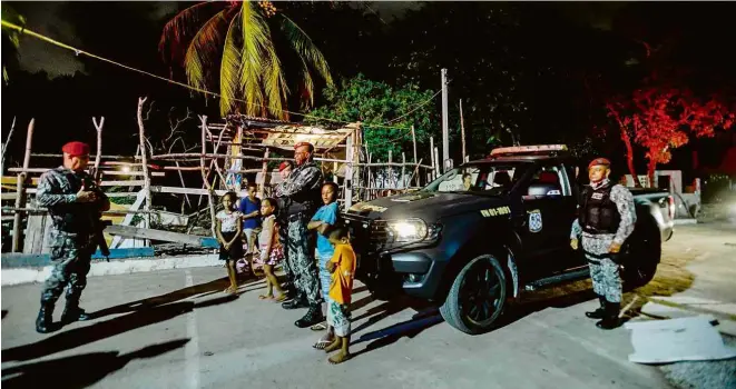  ?? Leo Caldas/Folhapress ?? Soldados da Força Nacional, em ronda no bairro do município de Paulista (PE), posam com crianças