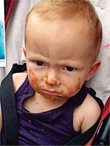  ??  ?? Who are you telling to smile? His face covered in chocolate, Alfie pouts on a day out