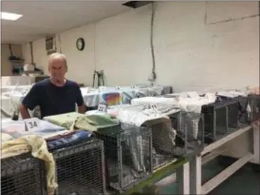  ?? PEG DEGRASSA — MEDIANEWS GROUP ?? Volunteer Michael Andre, of King of Prussia, stands among the dozens of traps holding cats that were recently brought into the Forgotten Cats shelter in Trainer. The trapped cats will all be sterilized and medically treated after an evaluation.