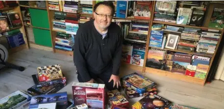  ??  ?? Conor Kelliher surrounded by jigsaws in the Gadaí Dubh bookshop in Baile Mhic Íre