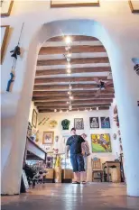  ??  ?? Zac Cox, grandson of The Rainbow Man’s owners, stands in the Santa Fe shop. Researcher­s took wood samples from the shop’s vigas to determine how old the building could be.