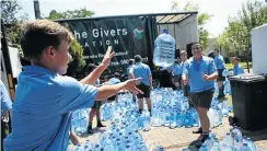  ?? Picture: Phill Magakoe ?? Pupils at Oos-Moot High School in Pretoria help to load donated bottles of water destined for drought-stricken Cape Town earlier this year.