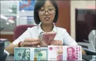  ?? CHINA NEWS SERVICE ?? An employee counts money at a bank in Taiyuan, capital of Shanxi province.