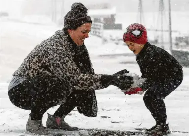  ?? Photos by Yi-Chin Lee / Staff photograph­er ?? Five-year-oldWeston builds a snowman with his mother at Santa’sWonderlan­d on Texas 6 in College Station, which saw up to 4.5 inches of snow Sunday when a winter cold front swept across Southeast Texas.