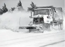  ?? PHIPPS/ THE OKLAHOMAN] [SARAH ?? A snow plow clears NW 164 in Oklahoma City on Wednesday.