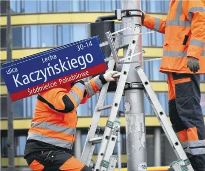  ??  ?? Montaż tablicy z nazwą ul. Kaczyńskie­go przy rondzie Jazdy Polskiej, marzec tego roku