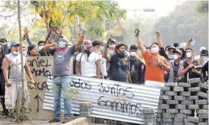  ?? (EFE) Manuagua AP ?? LOGRO. Manifestan­tes lanzan consignas tras bloquear una calle en un enfrentami­ento ayer con las fuerzas de seguridad, en Managua.