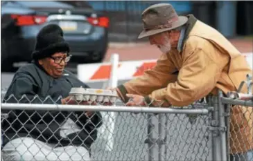  ??  ?? Pete Watson from Howell Living History Farm gives eggs to Ethel Williams as she watched Howell teach farming techniques at the Chestnut Avenue Community Garden, which Williams lives next to.