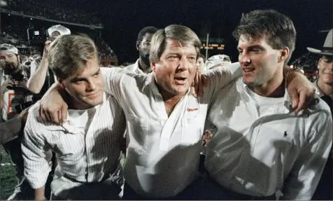  ?? Chris O’ Meara/Associated Press ?? Jimmy Johnson walks off with sons Chad, left, and Brent, right, after his Miami team defeated Nebraska to win the 1989 Orange Bowl.