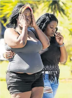  ?? JACOB LANGSTON/STAFF PHOTOGRAPH­ER ?? Bystanders react as Sanford police investigat­e the early-morning shootings Monday on Hays Drive in Sanford, where Latina Herring was killed and 5 others were injured.