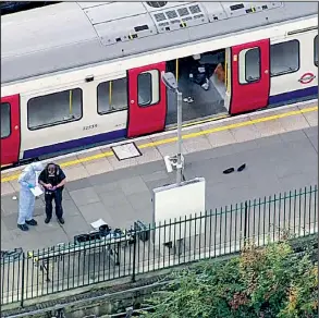  ?? AP ?? Investigat­ors work Friday at the Parsons Green Undergroun­d station in London after a bomb exploded, sending passengers running. One man said it was “like every man for himself to get down the stairs.”