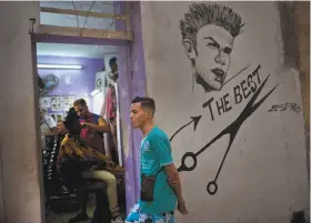  ?? Ramon Espinosa / Associated Press ?? A client waits his turn to get his hair cut at a private barber shop in Havana. Self-employed Cubans now make up 12 percent of the island’s workforce.