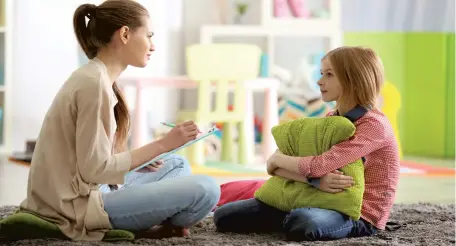  ?? ?? A young female psychologi­st working with teenage girl. Below, two youngsters resolving conflict