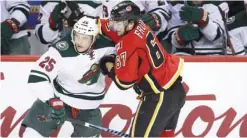  ??  ?? CALGARY: Minnesota Wild’s Jonas Brodin, left, from Sweden, battles with Calgary Flames’ Michael Frolik, from the Czech Republic, during first-period NHL hockey game action in Calgary, Alberta, Friday.— AP