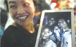  ?? AFPPIX ?? Relief ... A family member shows a picture of four of the 12 boys near the Tham Luang cave at the Khun Nam Nang Non Forest Park in Mae Sai on July 2.