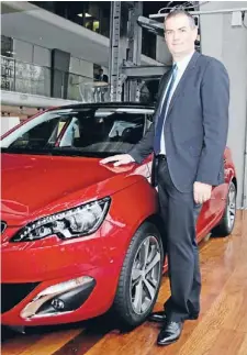  ?? Photo: REUTERS ?? Om way up: Head of Peugeot Brand Maxime Picat poses with a Peugeot 308. The carmaker reported that sales are starting to recover.