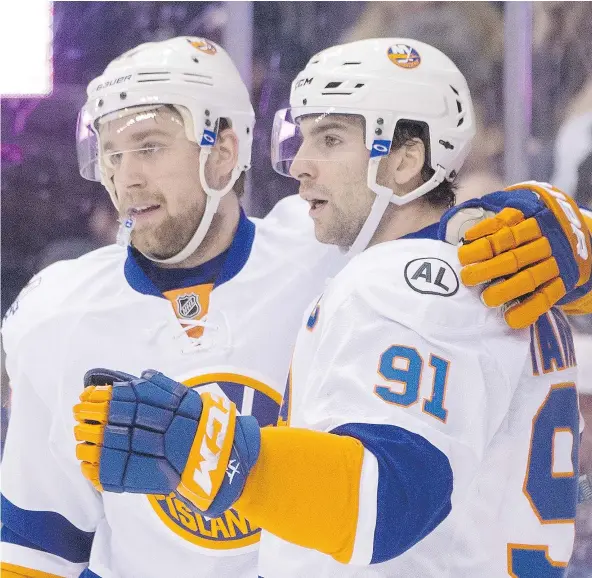 ?? — THE CANADIAN PRESS FILES ?? New York Islanders captain John Tavares, right, is having to get used to a pair of new linemates as the 2016-17 season begins. Tavares ended the pre-season playing between Andrew Ladd and Jason Chimera, a pair of free-agent acquisitio­ns.