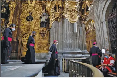  ?? (AP/Rebecca Blackwell) ?? Catholic clergy walk inside the Metropolit­an Cathedral in Mexico City on Sunday, the first day it reopened for public services amid the ongoing coronaviru­s pandemic.