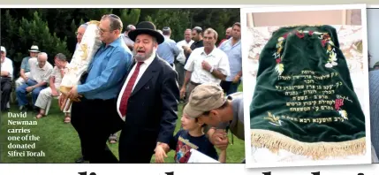  ??  ?? David Newman carries one of the donated Sifrei Torah