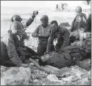  ?? THE ASSOCIATED PRESS FILE ?? U.S. Army medical personnel administer a transfusio­n to a wounded comrade, who survived when his landing craft went down off the coast of Normandy, France.