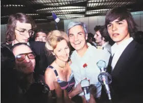  ?? AFP / Getty Images 1976 ?? Air France Capt. Michel Bacos (center) is welcomed by wife Rosemary outside Paris. He was rescued after not abandoning the passengers of his hijacked jet.