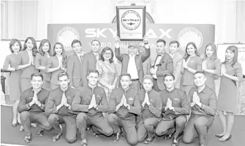  ??  ?? (Standing, from seventh left to right) Rafidah, Kamarudin, Bo Lingam and AirAsia Allstars employees pose with the award at the 2018 Skytrax World Airline Awards today.