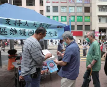  ??  ?? A resident signs in a street campaign to support national security legislatio­n for Hong Kong in Hong Kong on May 23