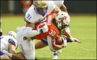  ?? Brody Schmidt The Associated Press ?? Tulsa defensive end Bryce Alonso puts the clamps on Oklahoma State’s Chuba Hubbard in the first half on Saturday.